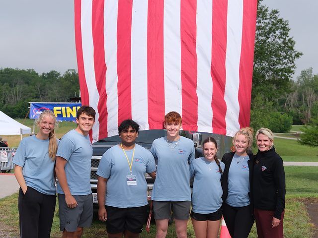 Honor Flight Youth Council members in front of a large American flag