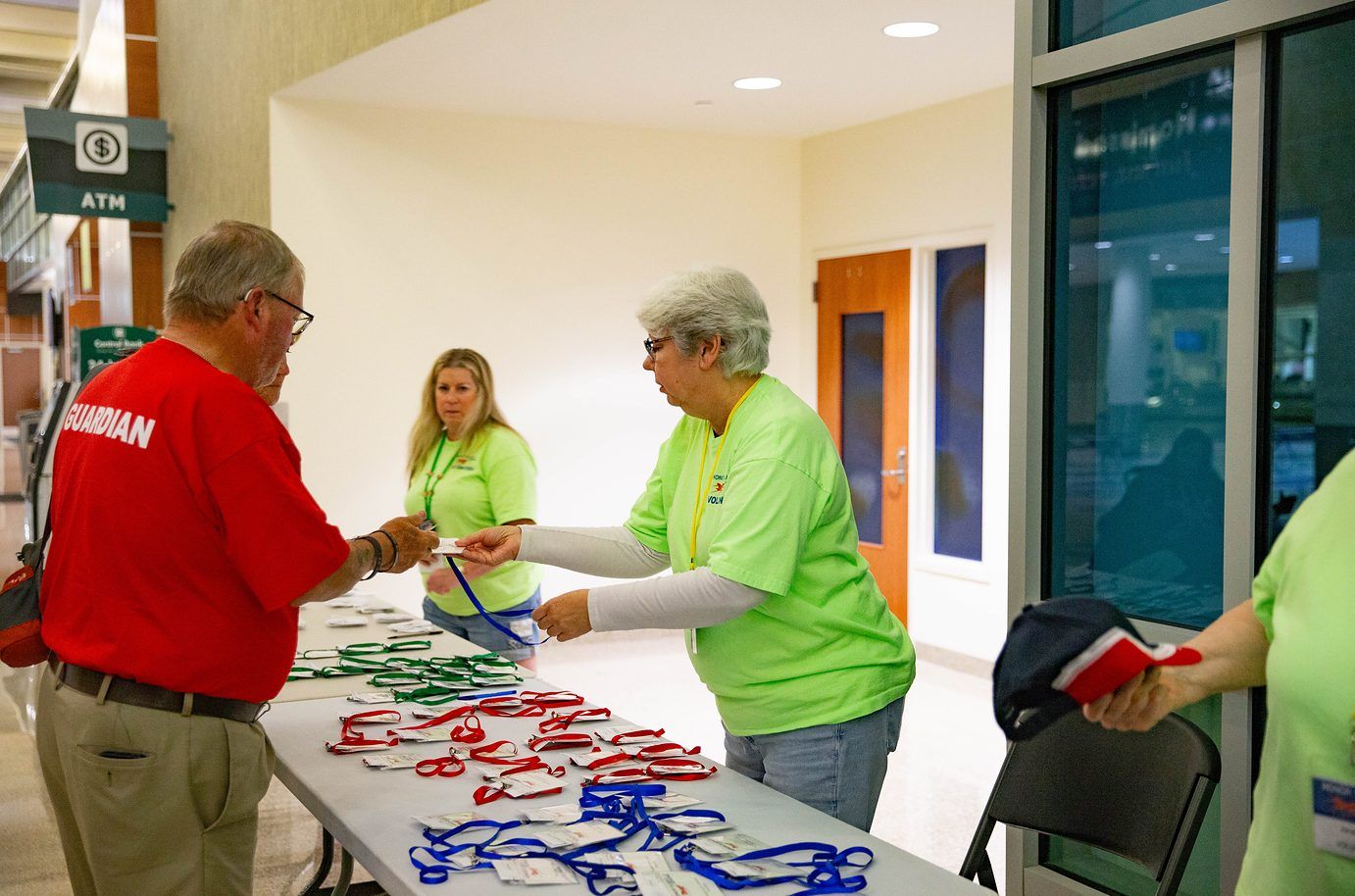 Volunteers handing out lanyards at a check-in table